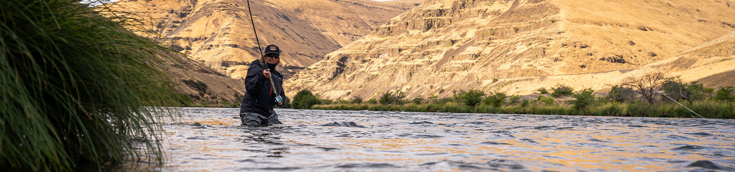 Angler cast rod wearing Grundens waders