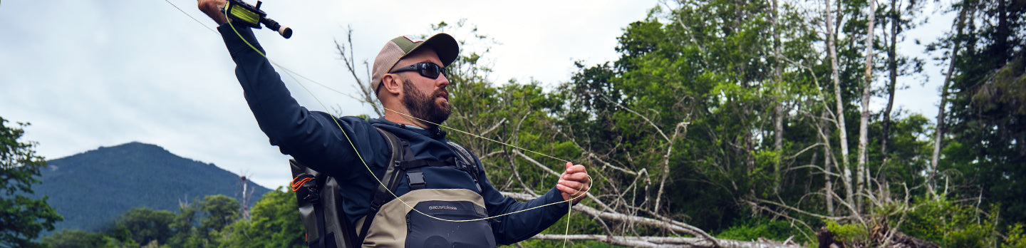 Angler cast rod wearing Grundens waders
