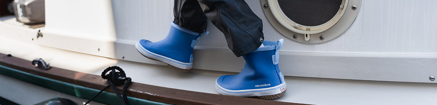 girl in kids rain gear holding a salmon. 