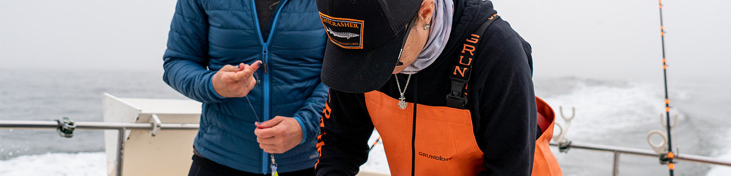 two women on fishing boat in grundens gear. 