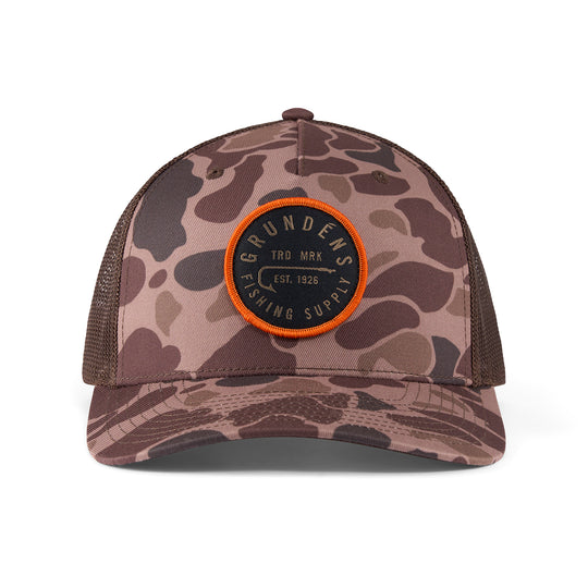 Camo-patterned trucker hat with a round patch featuring "Grundens Fishing Supply" in black and orange.